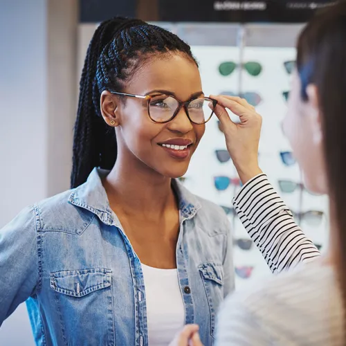 Dispenser fitting glasses onto their paitent's face