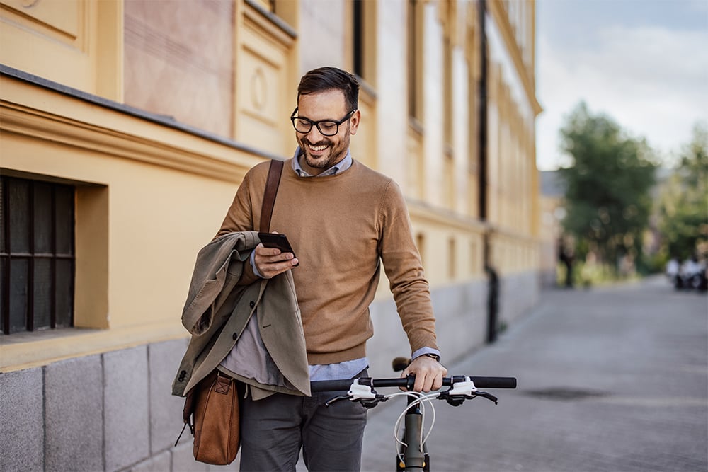 Dark-haired man with glasses and beige sweater 